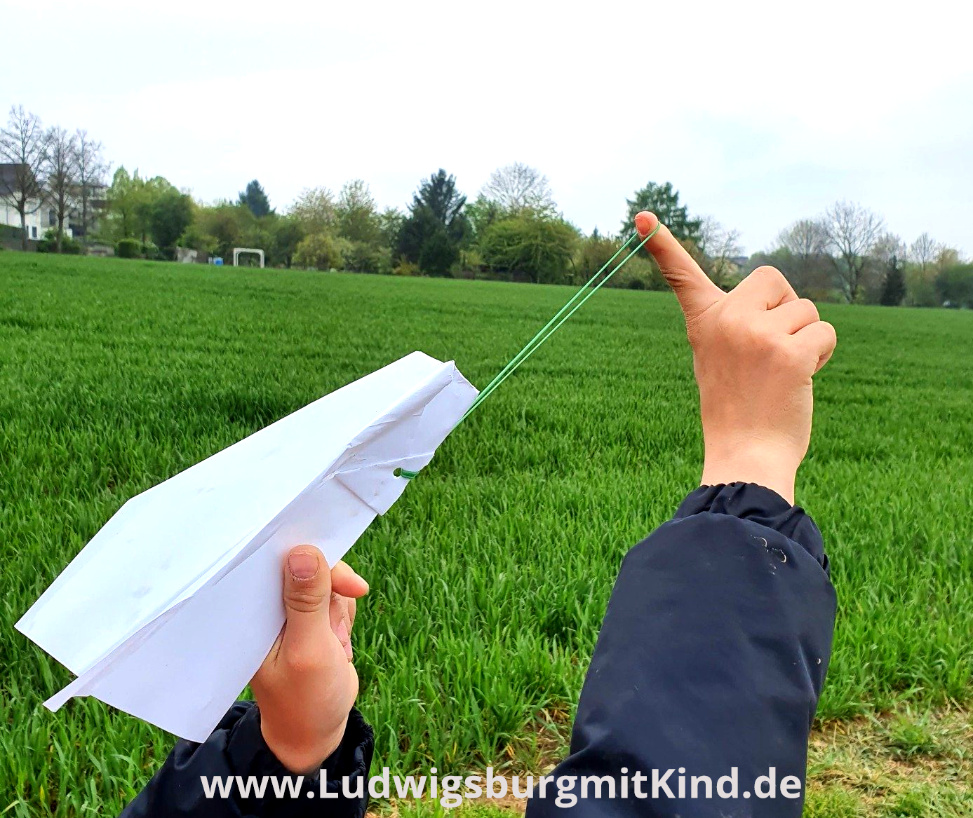 Ein Kind lässt einen Papierflieger fliegen