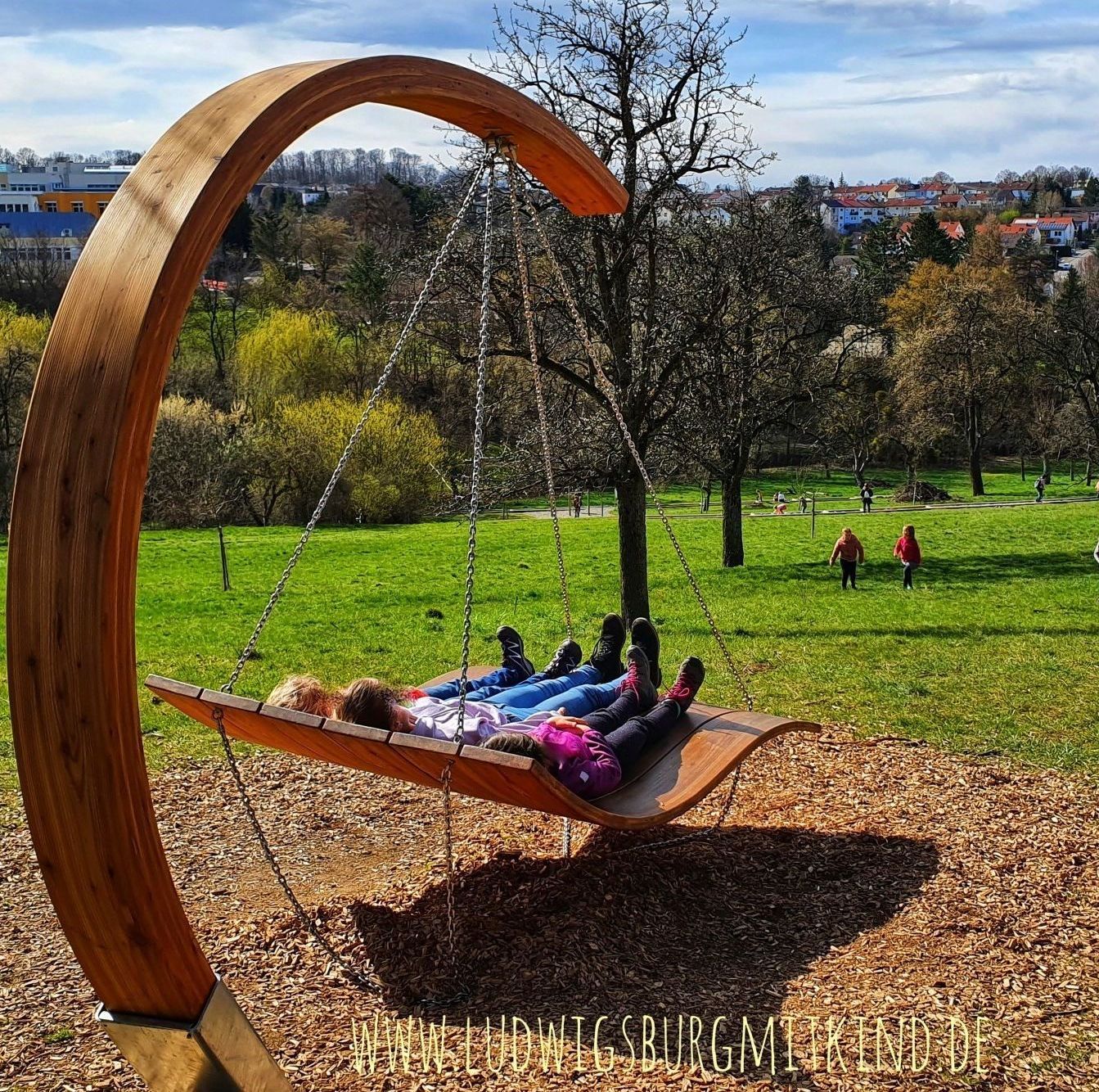 Kinder balancieren barfuß auf einem Balken des Barfußpfades, Schaukelwegs in Hechingen.