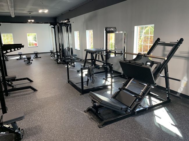 Wide shot of leg press belt squat cable machine and benches