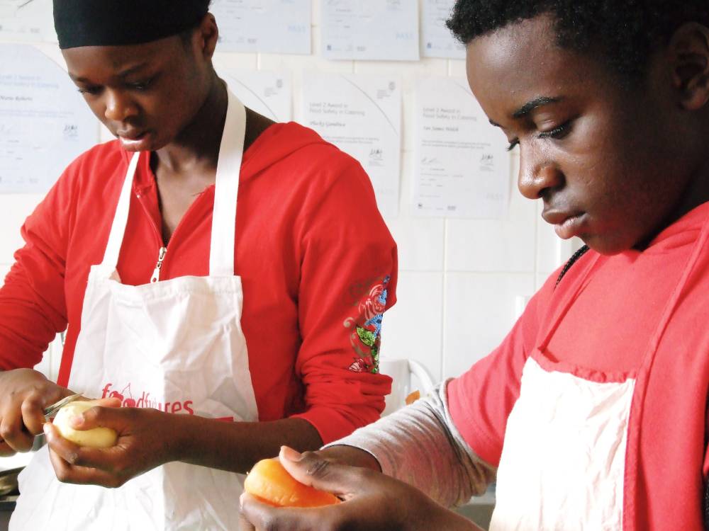 Two young people peeling potatoes