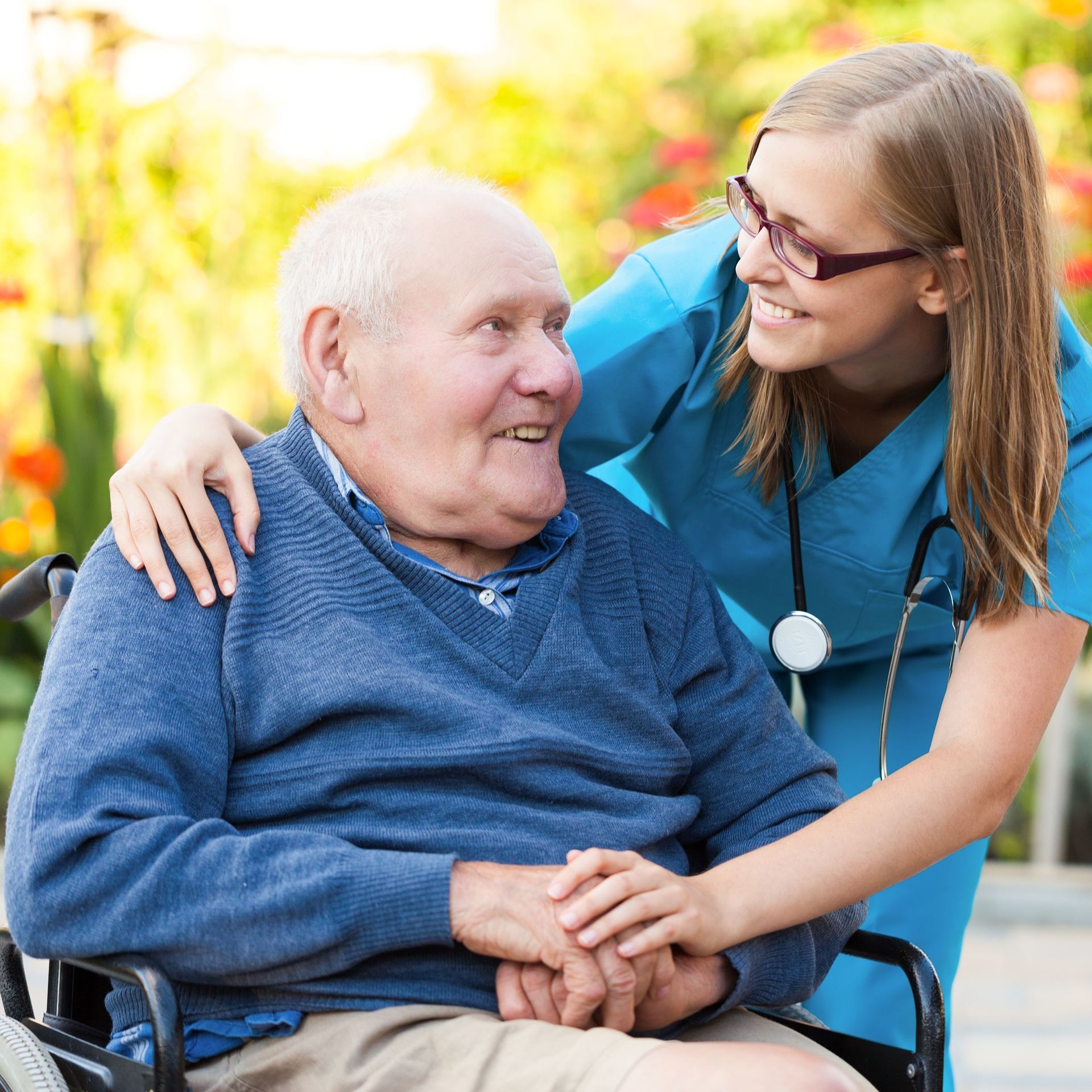 Spaziergang eines Kunden im Rollstuhl mit seiner Pflegerin