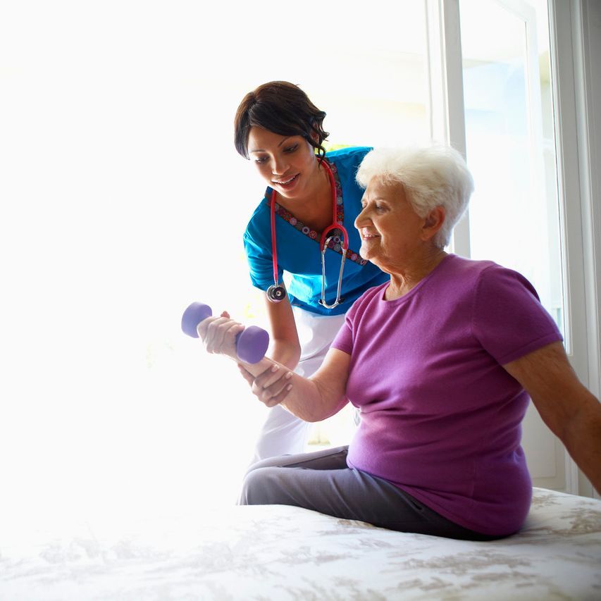 Kundin beim Hanteltraining mit einer Pflegekraft