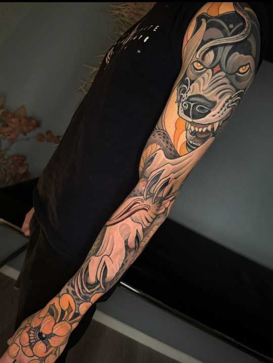 Neotraditional Wolf Sleeve Tattoo mit Chrysantheme auf der Hand. Raubtiermotiv von Tattoo Artist P. Schneider Berlin Mitte.