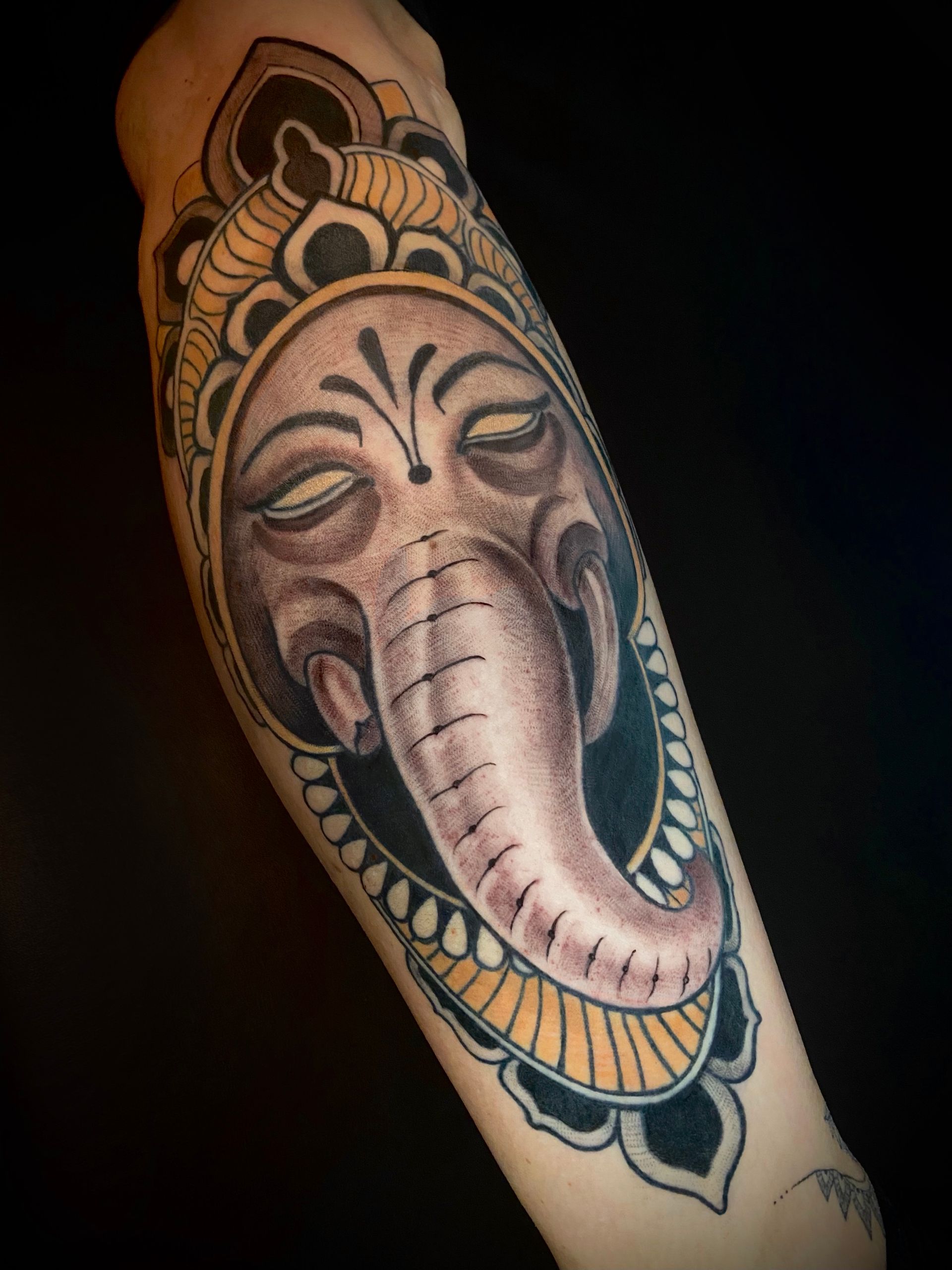 Ganesha Tattoo mit dezenten Farbakzenten auf der Wade. Tätowiert im neotraditionellen Stil in Berlin Mitte Tiergarten.