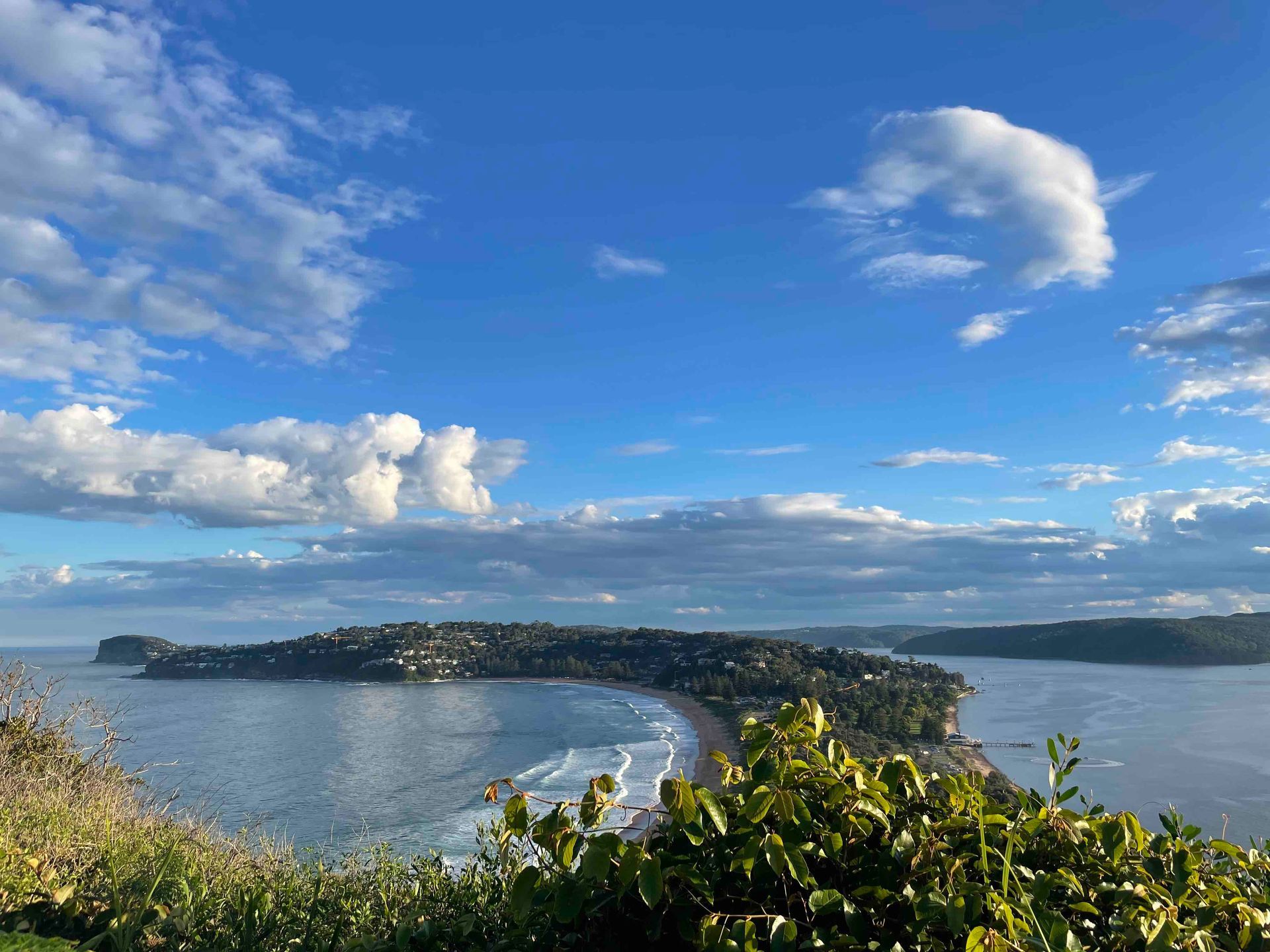 View from a hill top of a promontory surrounded on both sides by open water.