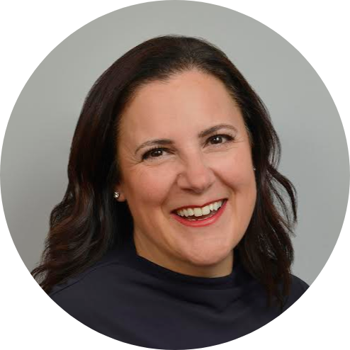 Headshot of Julie smiling, grey background