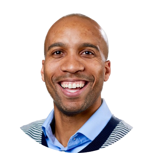 Headshot of Thomas smiling against a pale background.