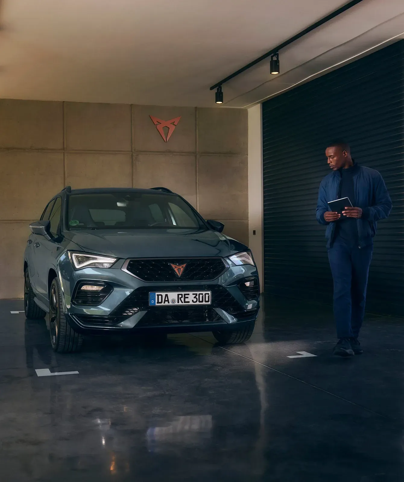 Ein Mann steht vor einem Cupra und schaut es ringsum an