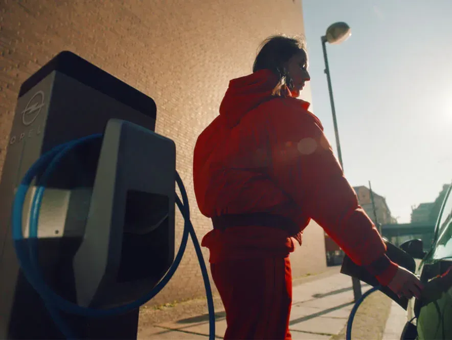Frau lädt Elektroauto an der Wallbox