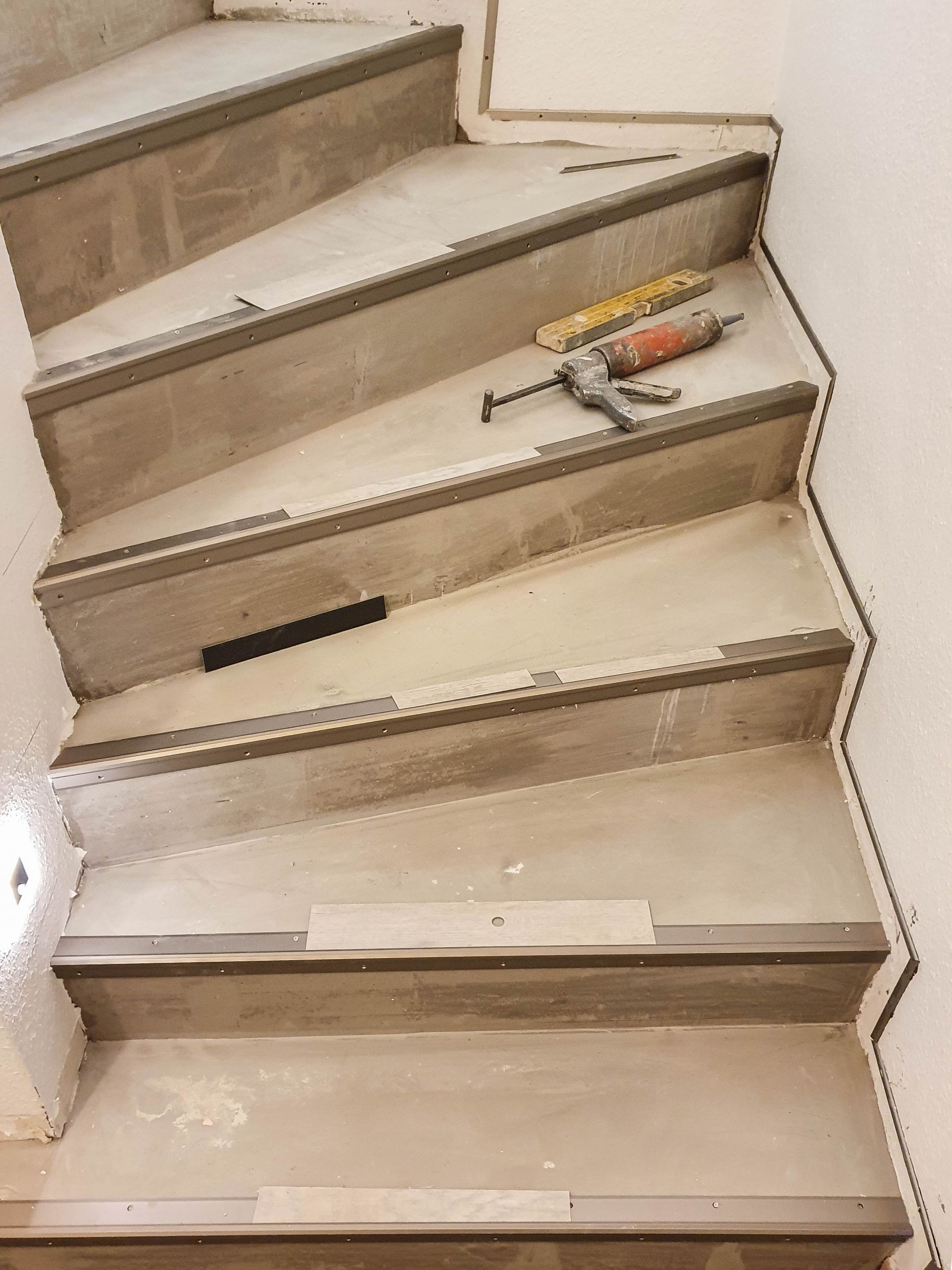 Betontreppe begradigt, Alu-Kantenprofile montiert und mit Designbelag belegt