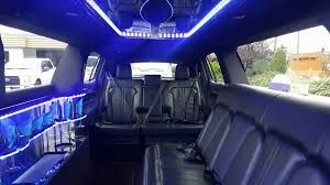 Luxury interior of a stretch limousine featuring premium leather seating and ambient blue lighting.
