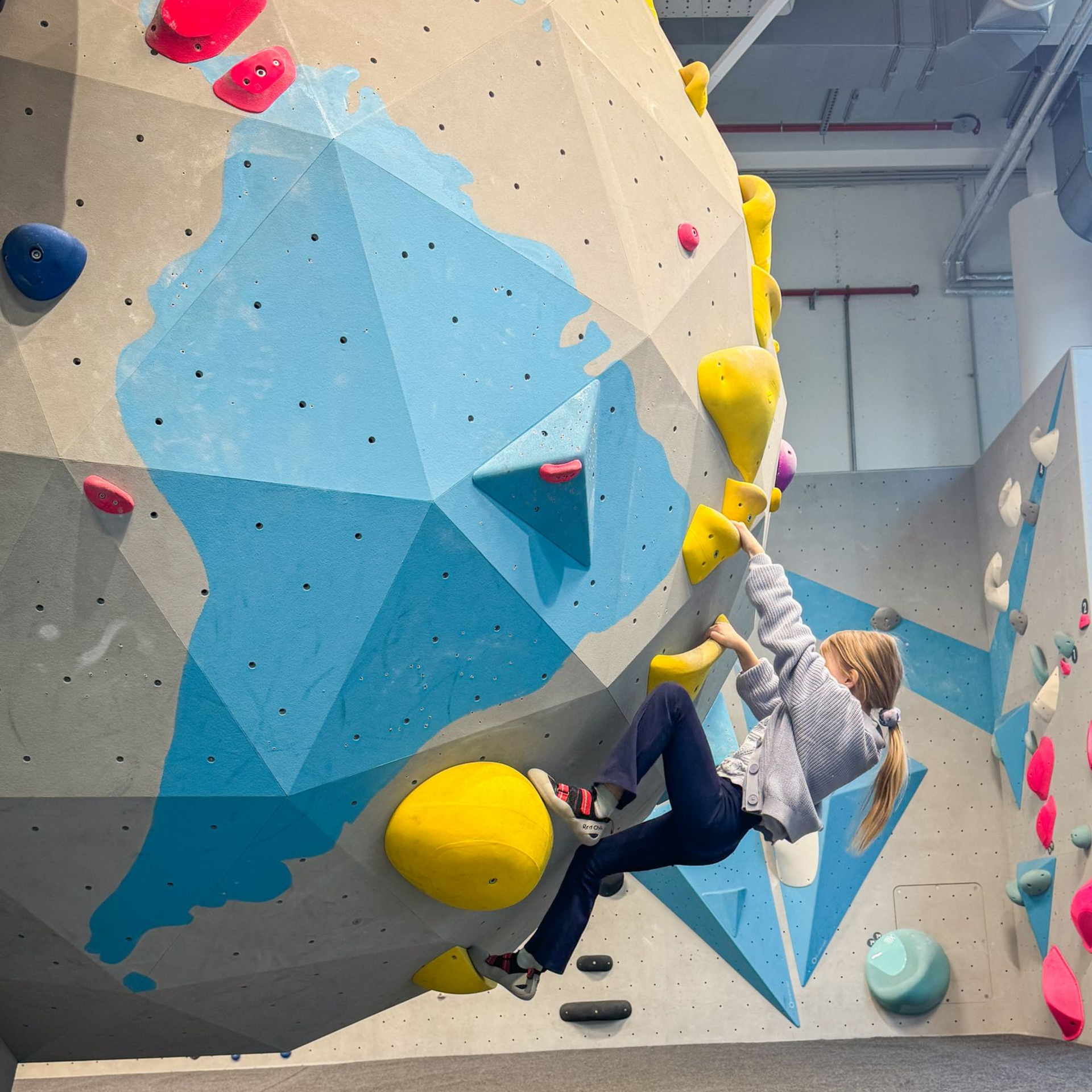 Blick auf ein Kind welches an einer großen Kugel bouldert