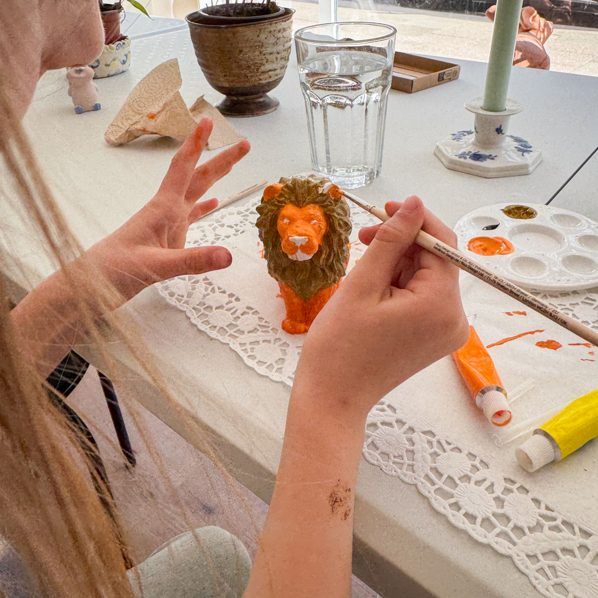 Blick auf zwei Kinder beim Gipsfiguren bemalen