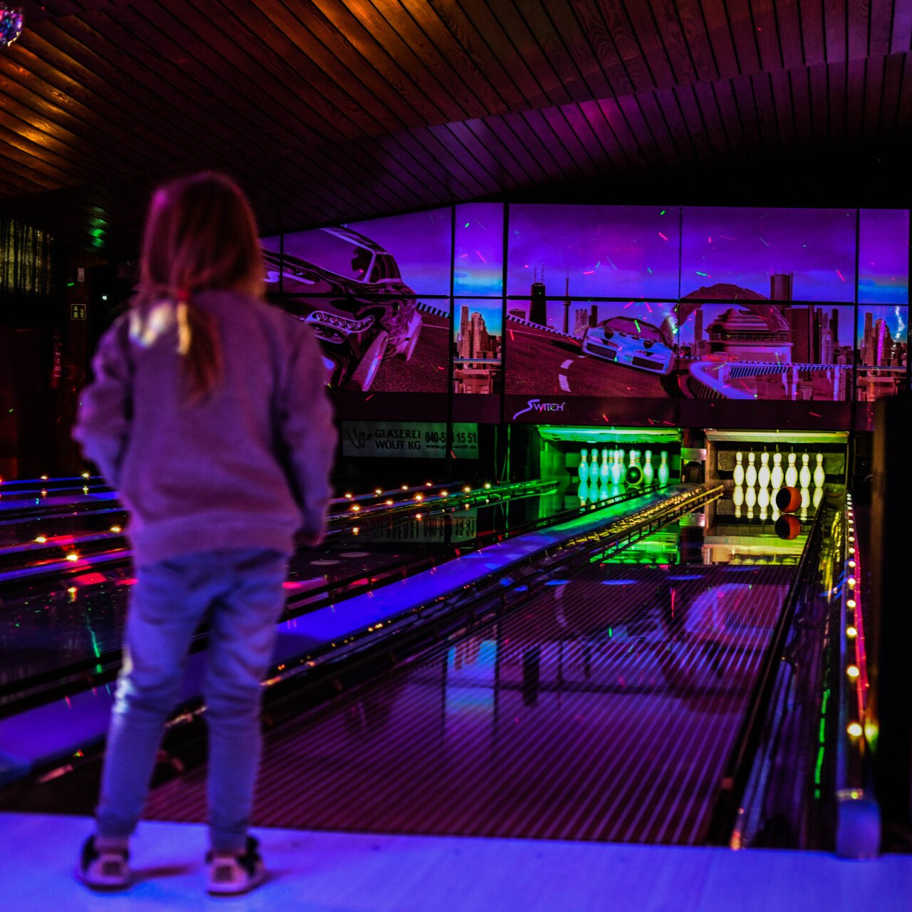 Kindergeburtstag Pins Norderstedt Bowling Mädchen schaut der Bowlingkugel hinterher