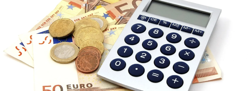 Verschiedene Euro-Banknoten und Münzen neben einem Taschenrechner auf einem Tisch, die zum Forderungseinzug nach italienischem Inkassorecht dienen.