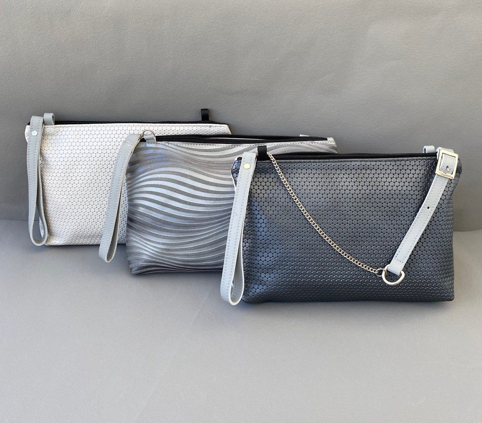 Ledertaschen mit geprägten Hexagon- und Wellenmuster. Schultertasche mit Kettenriemen