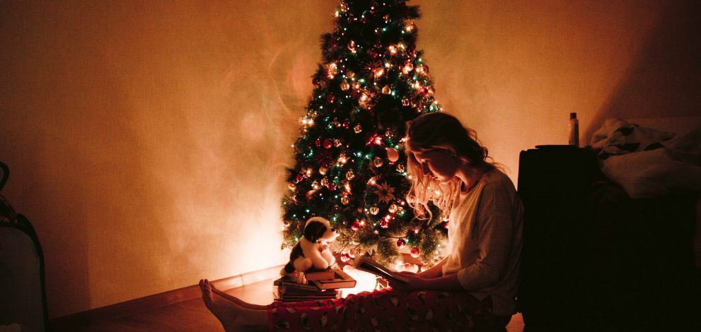 Chica junto al árbol de Navidad.