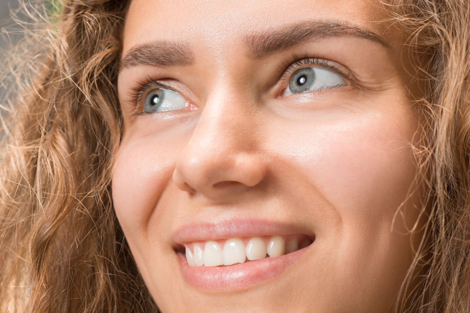 Strahlende Frau mit natürlichem Make-up, repräsentiert vegane und tierversuchsfreie Naturkosmetik.