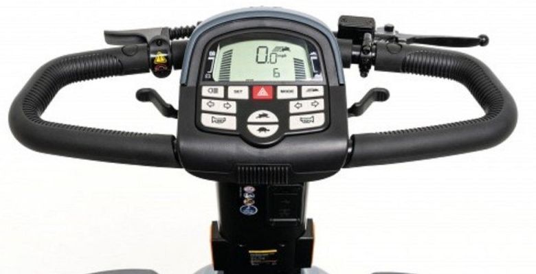 Tableau de bord et commandes du scooter Pride Victory XL 140, montrant l'écran LCD, les boutons de commande pour la vitesse, les lumières, l'avertisseur sonore et un panier avant.