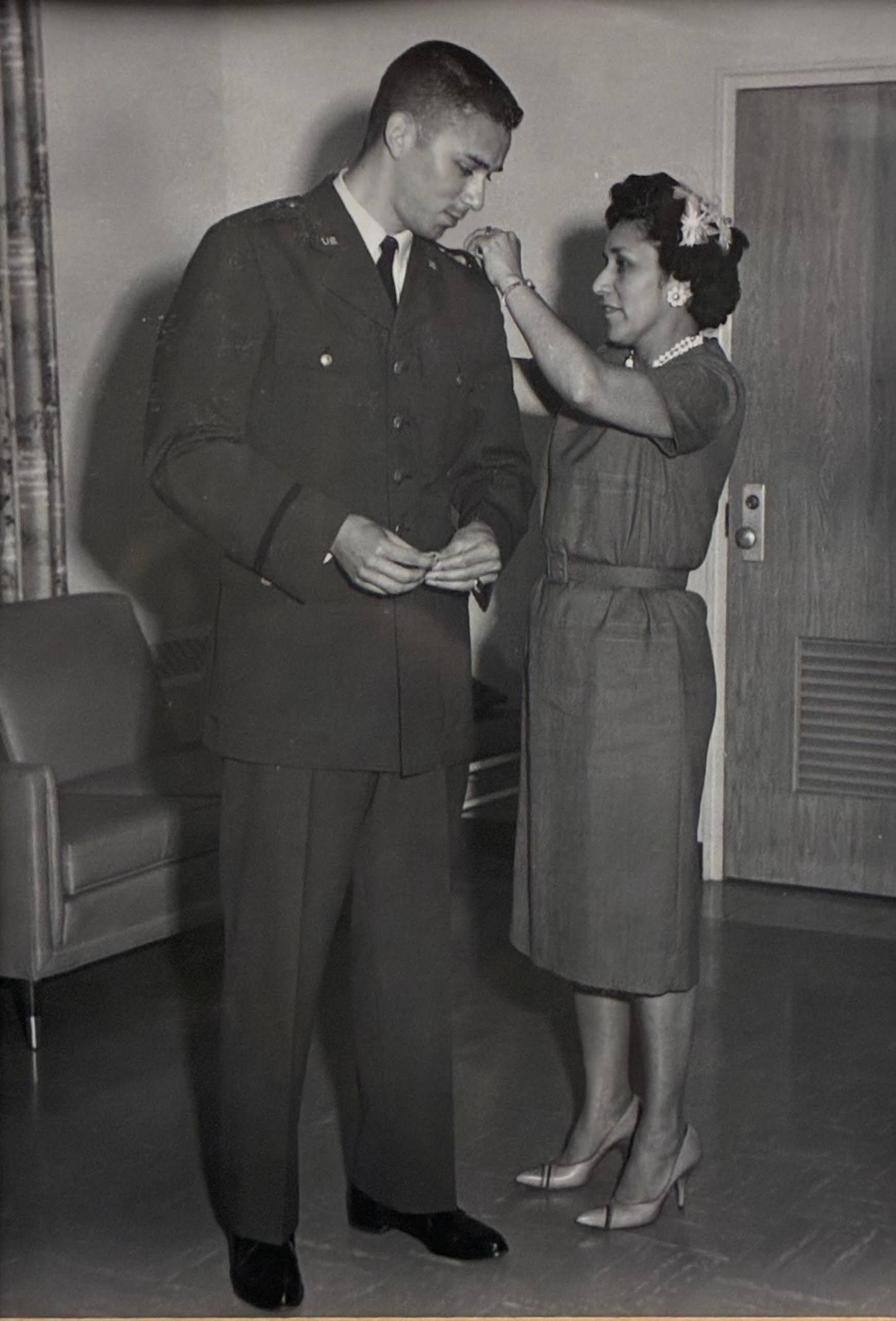Vintage photo of woman adjusting military uniform, formal dress, historic military fashion