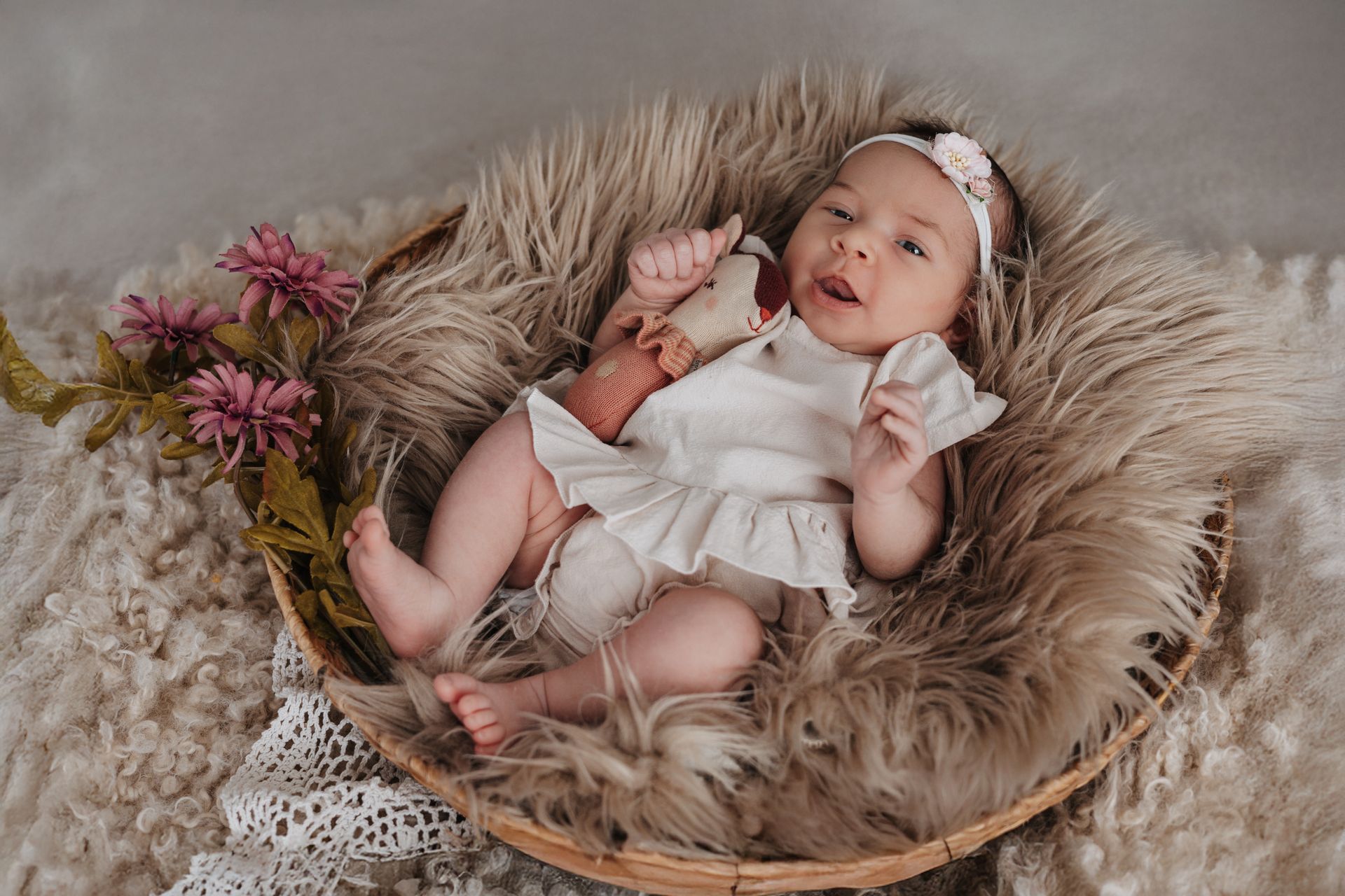 Neugeborenes Baby mit rosa Kuschelfigur
