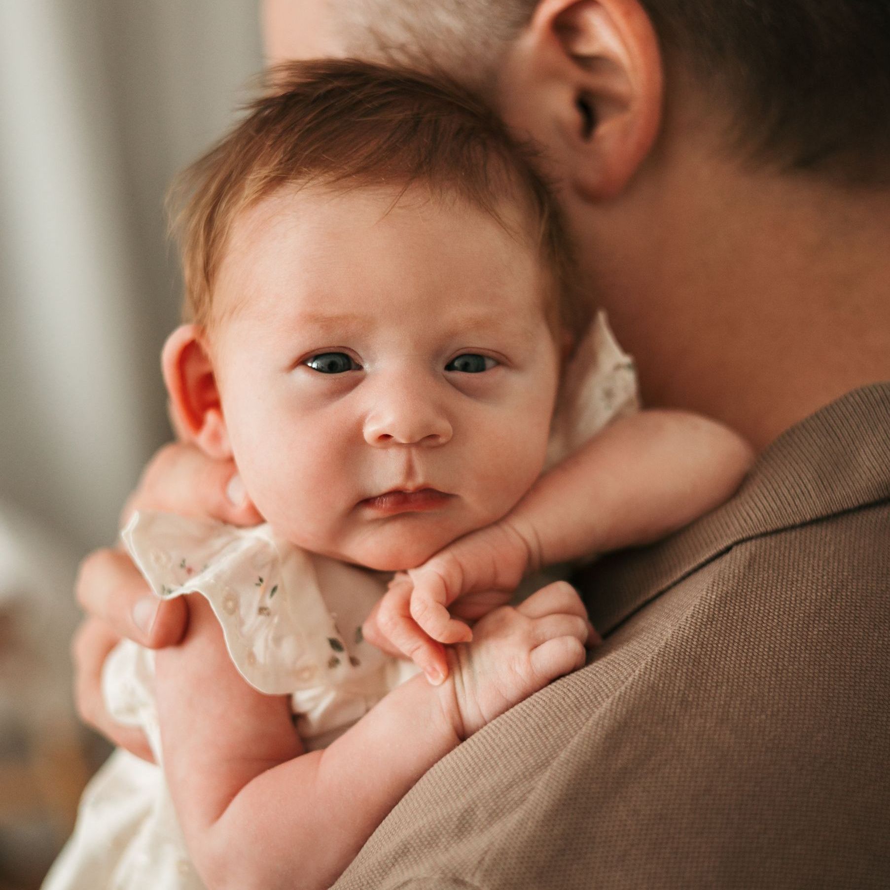 Neugeborenes auf dem Arm des Vaters