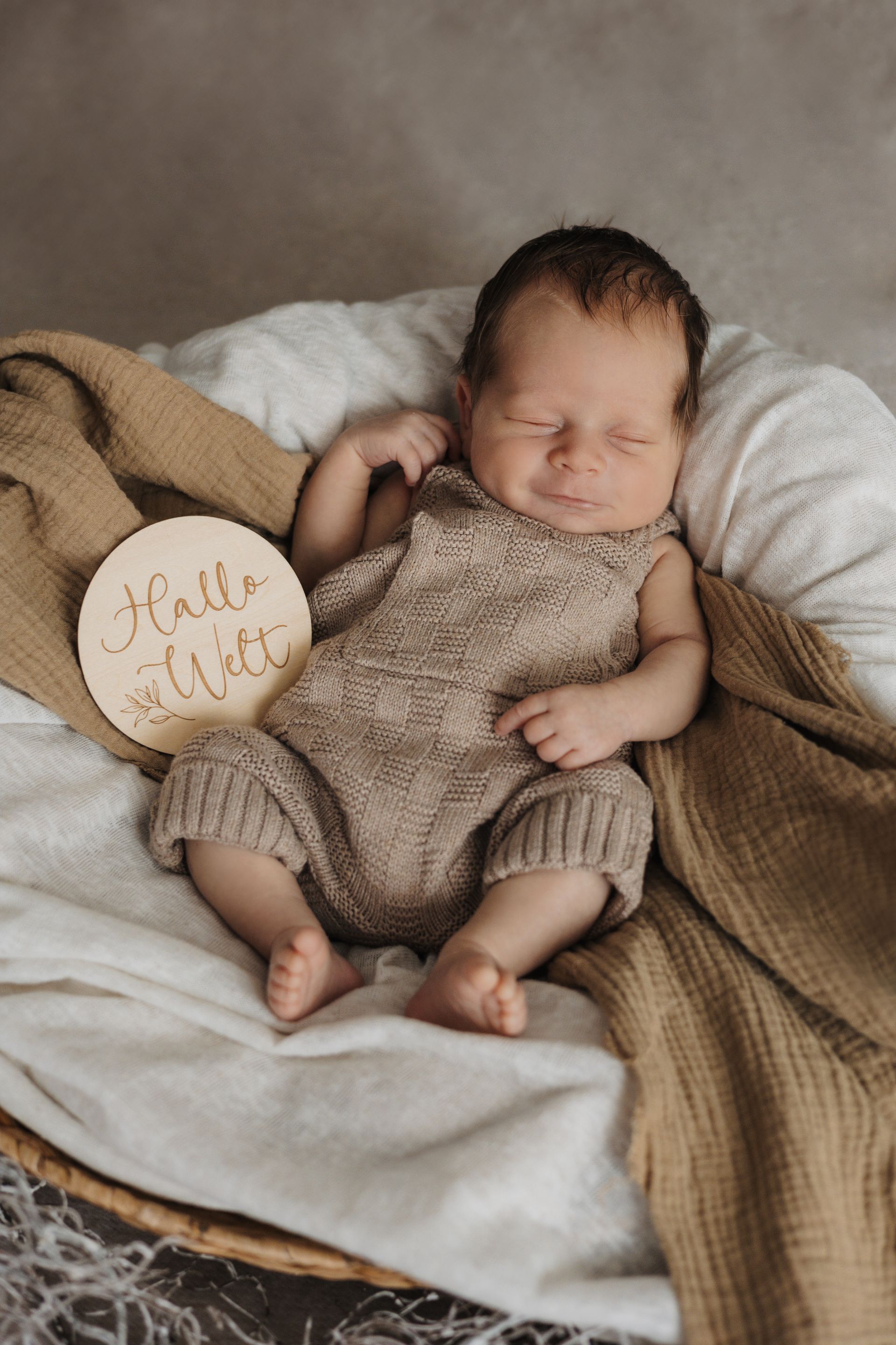 Neugeborenes Baby mit Hallo Welt Schild