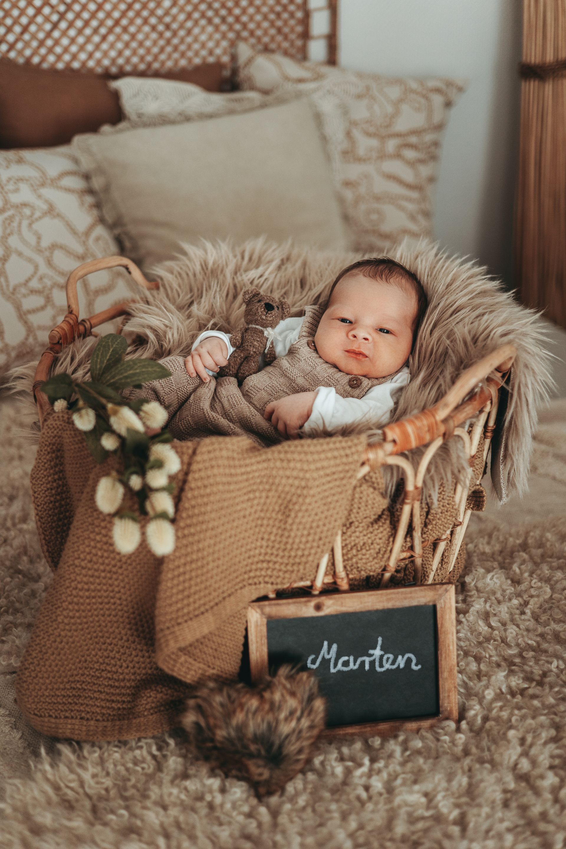 Neugeborenes Baby im Korb mit einer Tafel