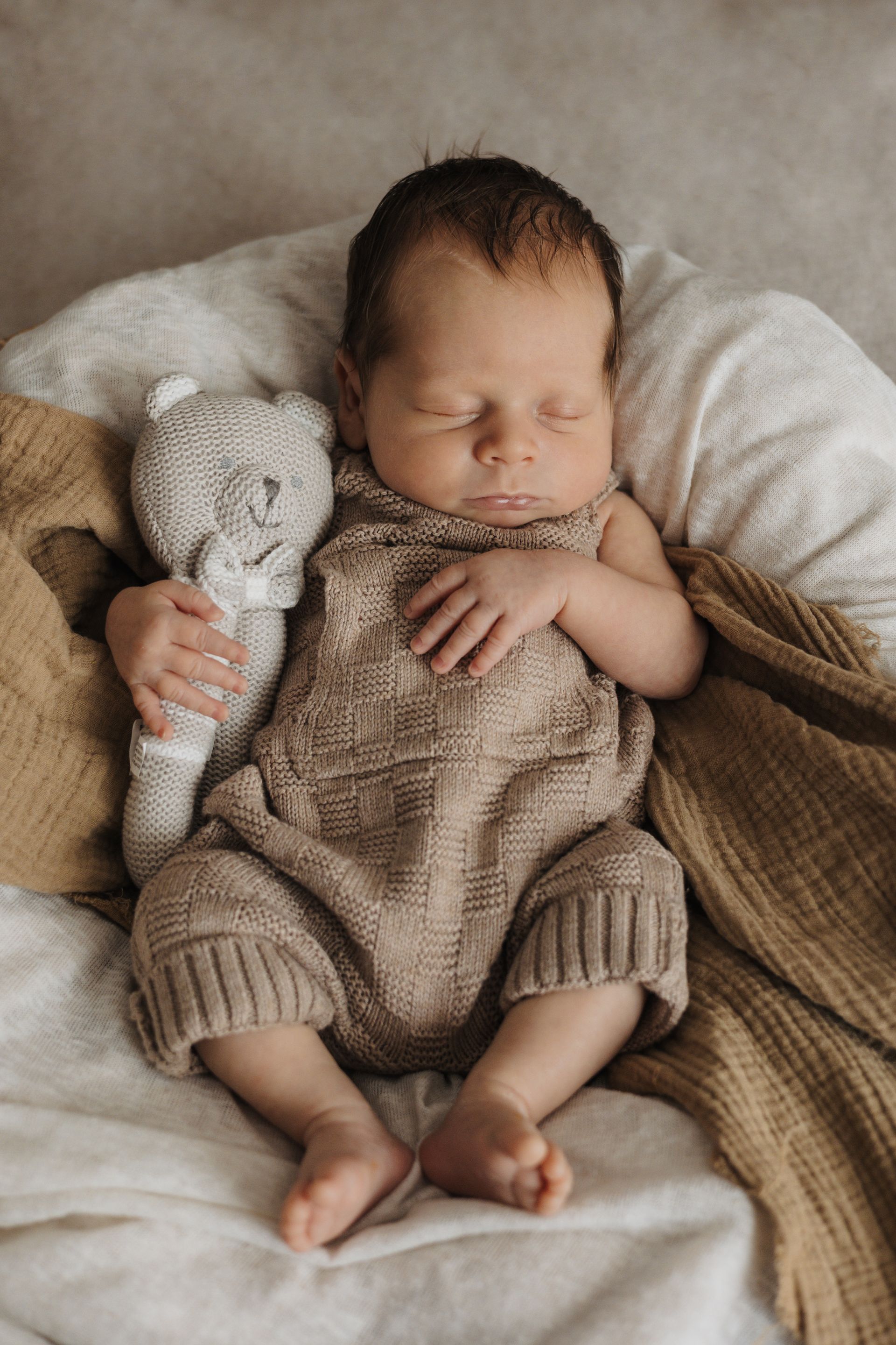 Neugeborenes Baby und sein Teddy