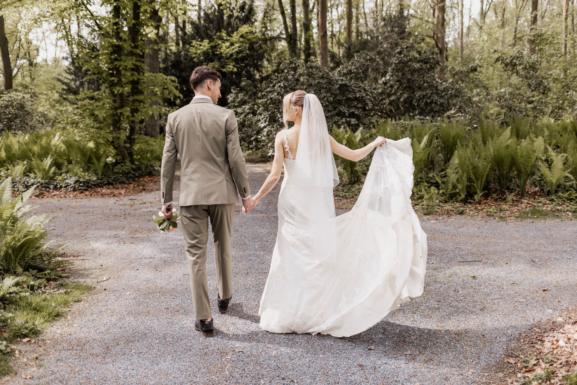 Brautpaar läuft beschwingt durch den Kurpark Bad Sassendorf Hochzeitsmoment