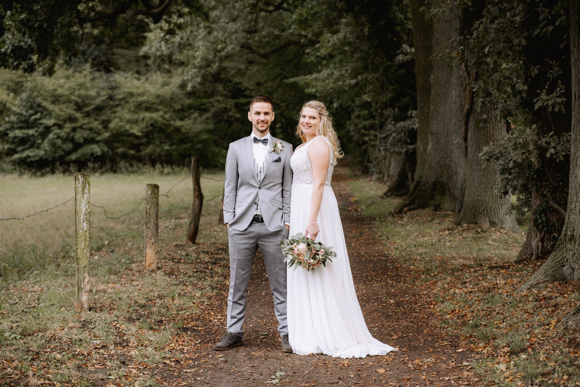 Brautpaar unter einer Baumallee