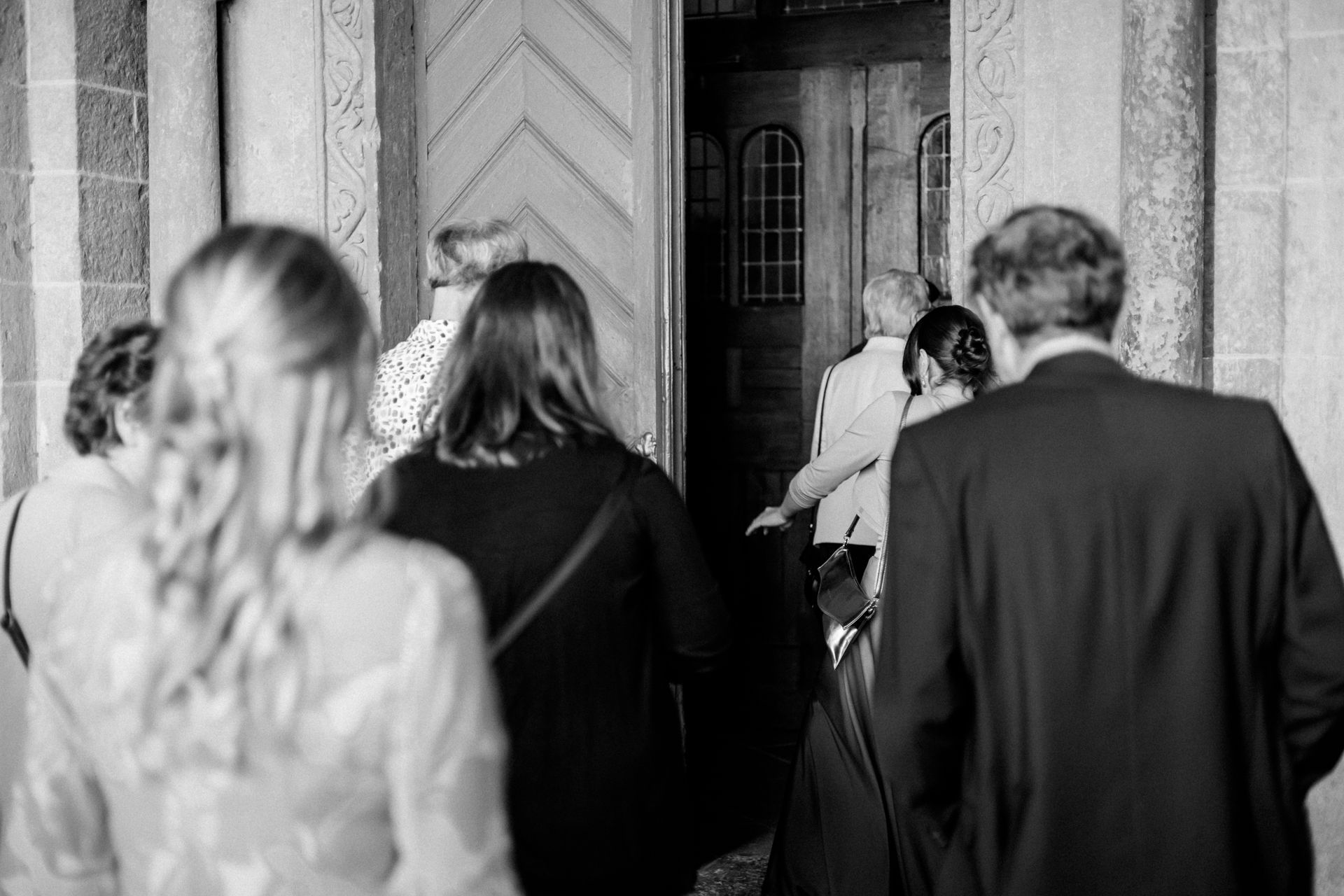 Gäste schreiten in die Kirche ein, bereit für die Hochzeitsfeier