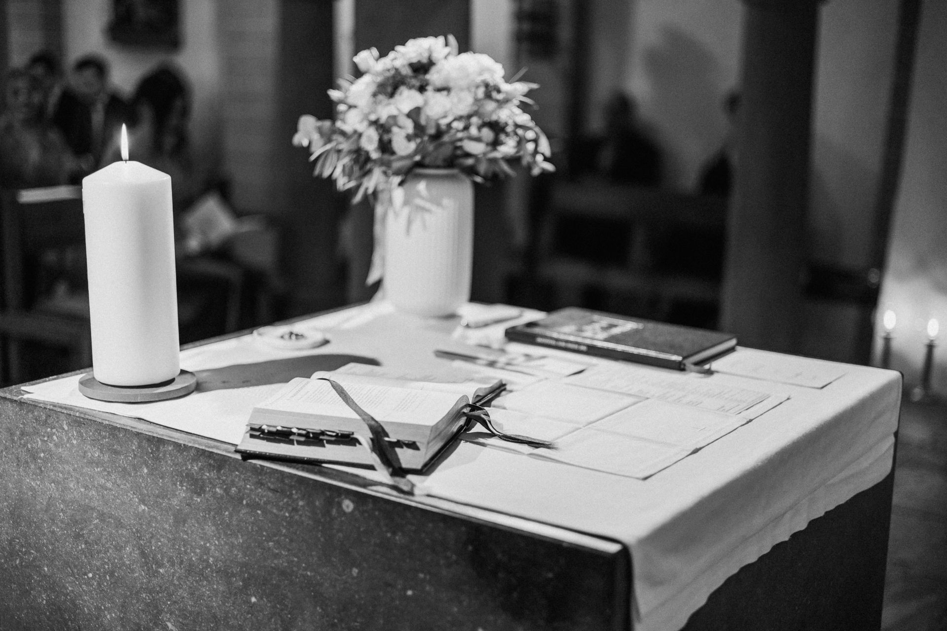 Ein Altarbild mit einer brennenden Hochzeitskerze, die sanftes Licht spendet