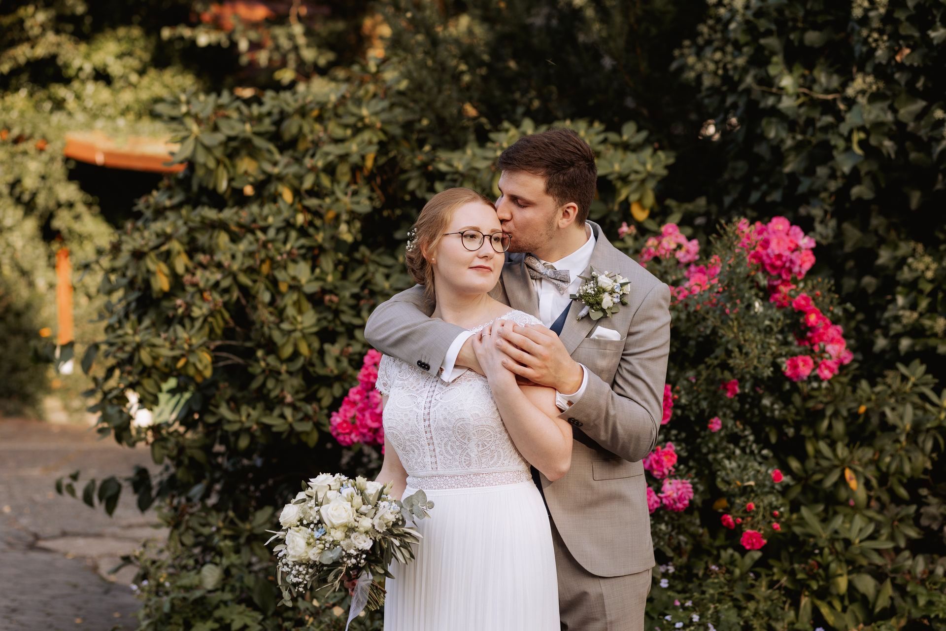 Brautpaar vor blühender Blumen am Thinghof