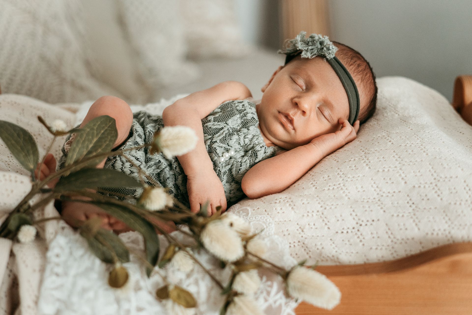 Neugeborenes Baby mit einem grünen Haarband