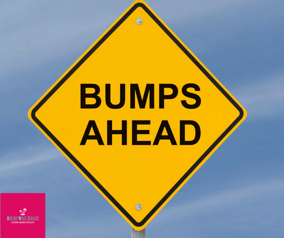 Yellow diamond road sign reading Bumps Ahead