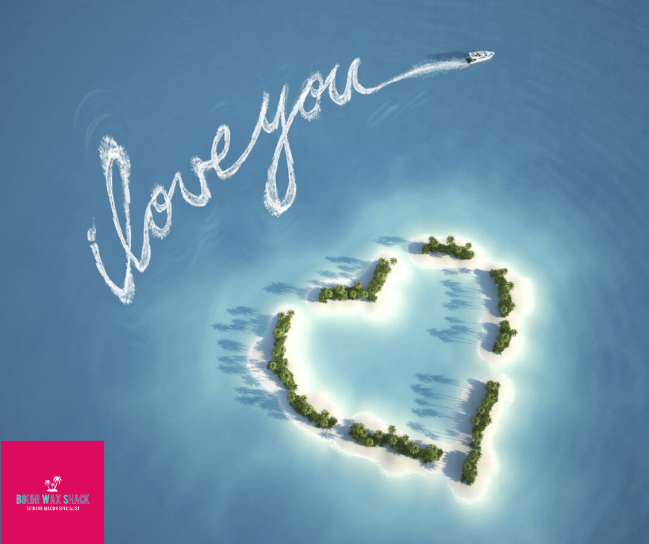 Heart shaped island with a speed boat spelling out i love you in it's wake