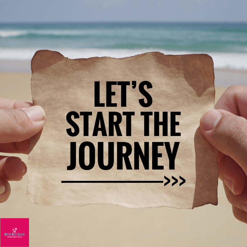 beach scene with person's hands holding a piece of paper reading let's start the journey