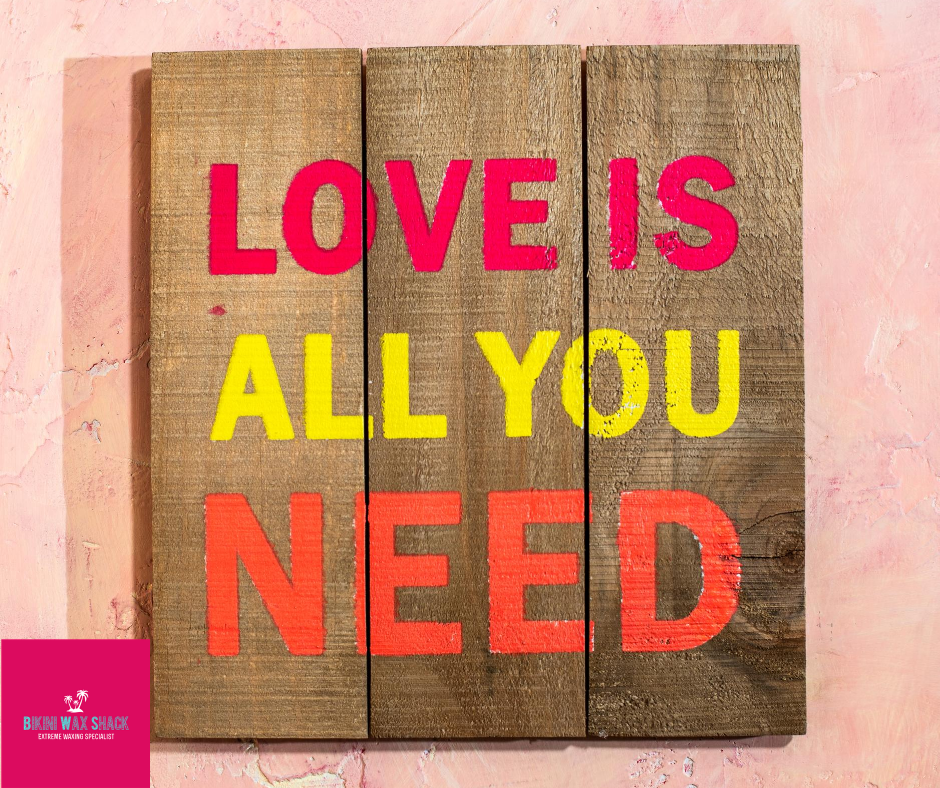 Love is all you need slogan on wooden board