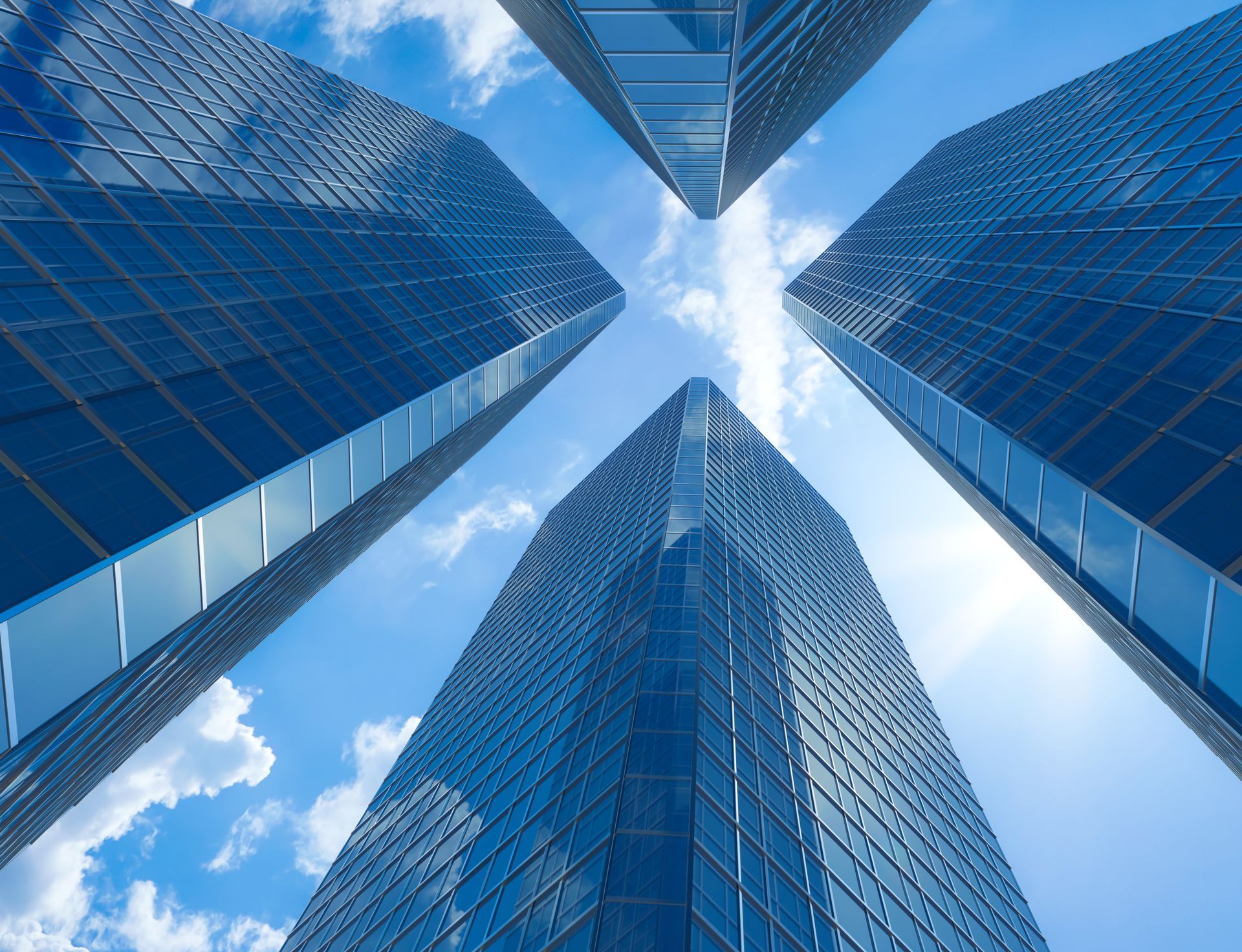 Die Aufnahme zeigt vier gläserne Hochhäuser, die in den Himmel aufsteigen.