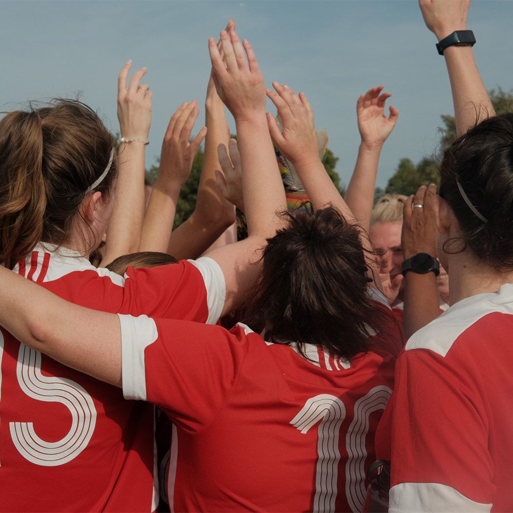 A women's football team huddle before a match