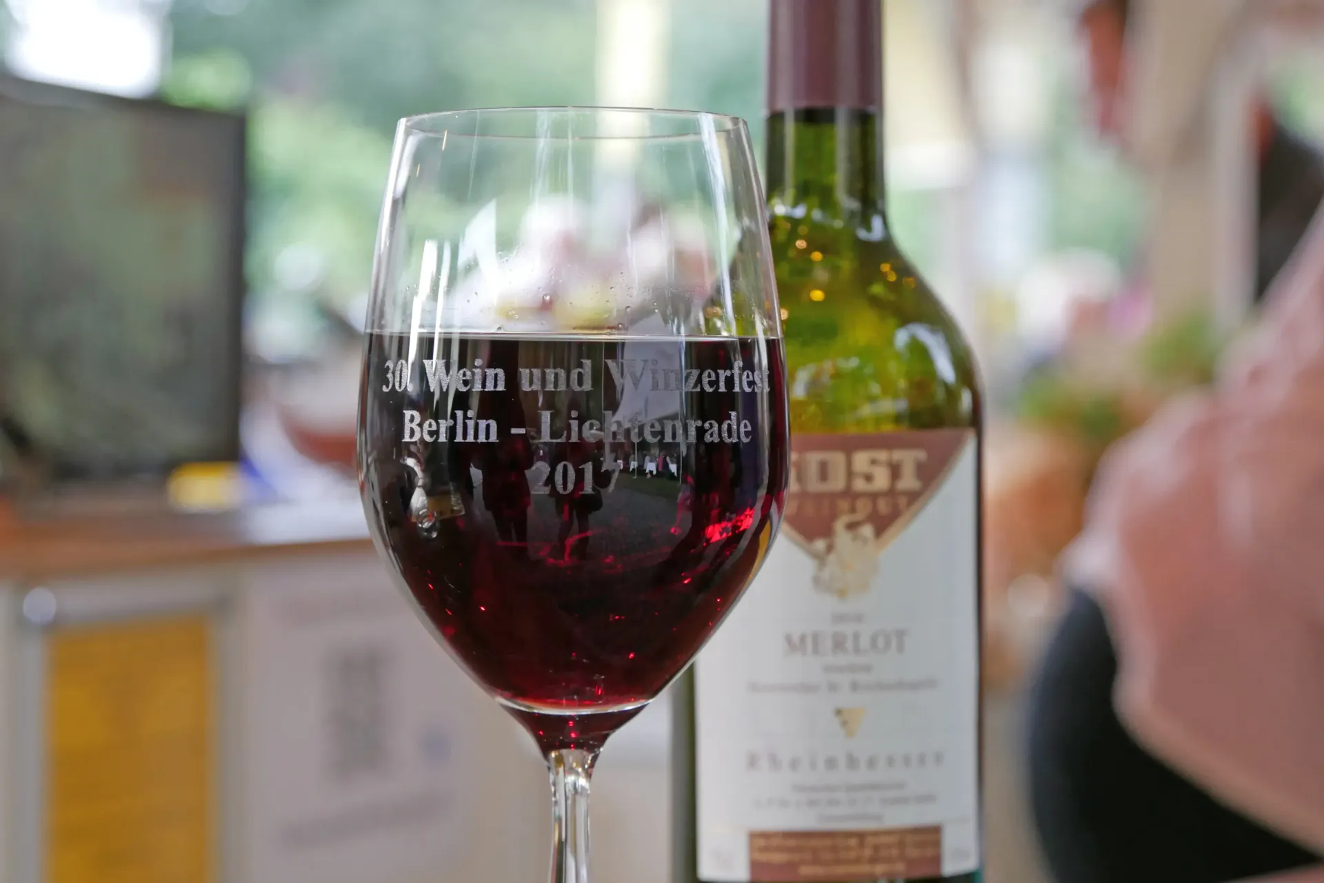 Weinglas mit Gravur: 30 Jahre Wein- und Winzerfest Lichtenrade 2017 vor einer Merlot-Flasche