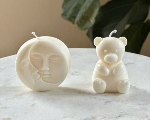 Alina Döhnel: 2 Kerzen, eine Kerze ist ein wollweißer, niedlicher Kuschelbär. Bei der zweiten Kerze küsst der wollweiße Sichelmond den wollweißen Vollmond.