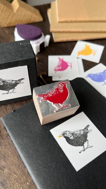 Gerhard Peterichs Werktisch mit Stempel und Stempelkissen. Das Motiv sind farbenfrohe Vögel - vielleicht der Vogel des Jahres?