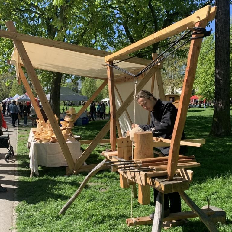 Pirmin und Jero Lehr arbeiten an der fußbetriebenen Wippdrehbank - gern auch unter freiem Himmel. Auch den vor Sonne und Regen schützenden Stand mit Segel haben sie selbst gebaut.