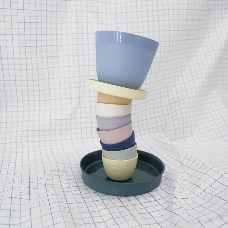 Aus Susanne Steckels Atelier: farbige Schüsseln, Teller und Tablett aus Porzellan übereinander gestapelt