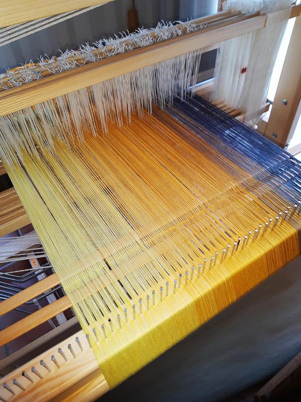Christine Ostendorfs fertigt Tuchwaren und kombiniert schöne Garne zu wunderbaren Farbverläufen. Sie sehen wir das blau-gelbe Tuch bei der Entstehung.