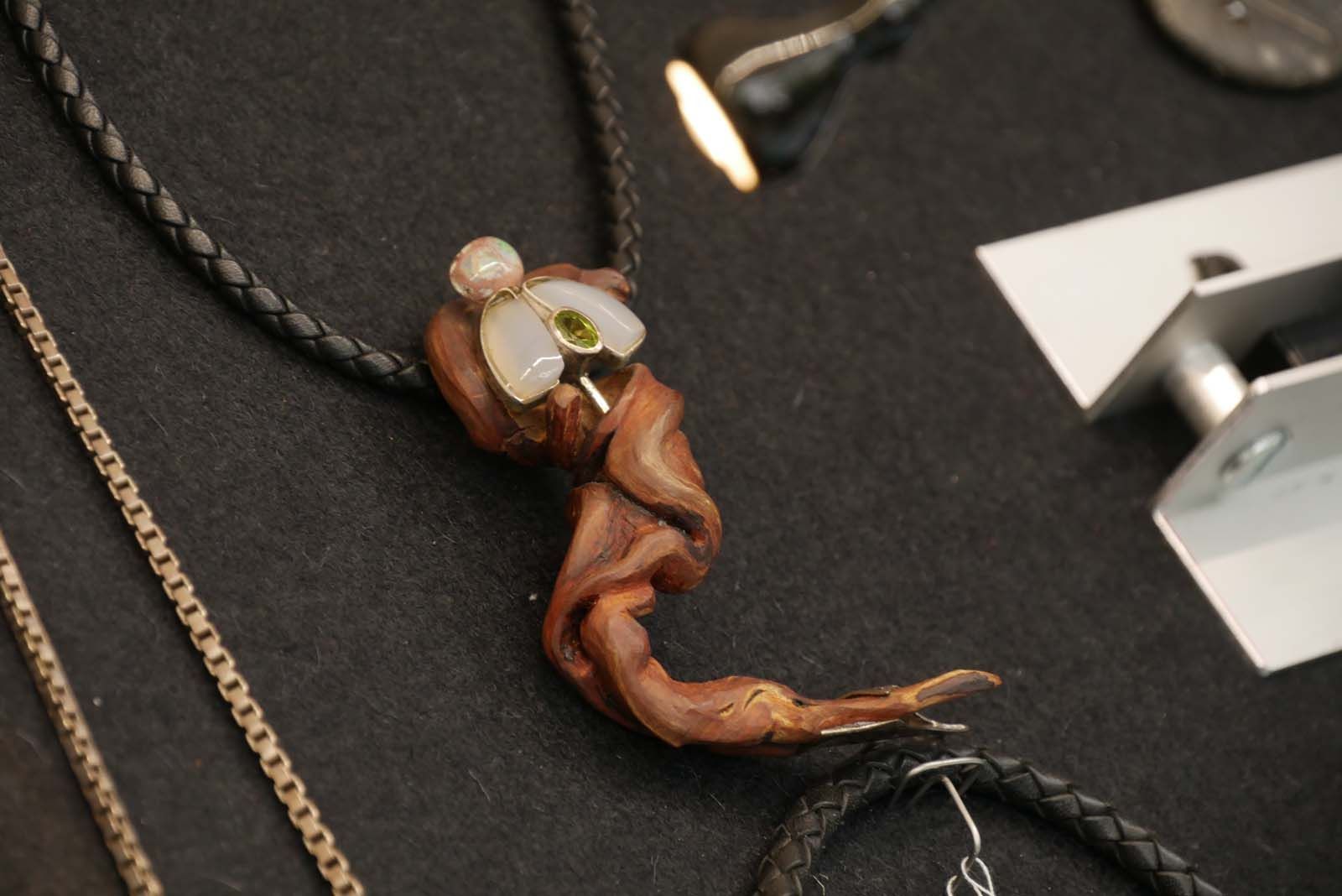 Matthias Hentschel ist Designer hochwertigen Schmuck, hier aus Wurzelholz mit Schmuckstein in Form eines Schmetterlings besetzt.