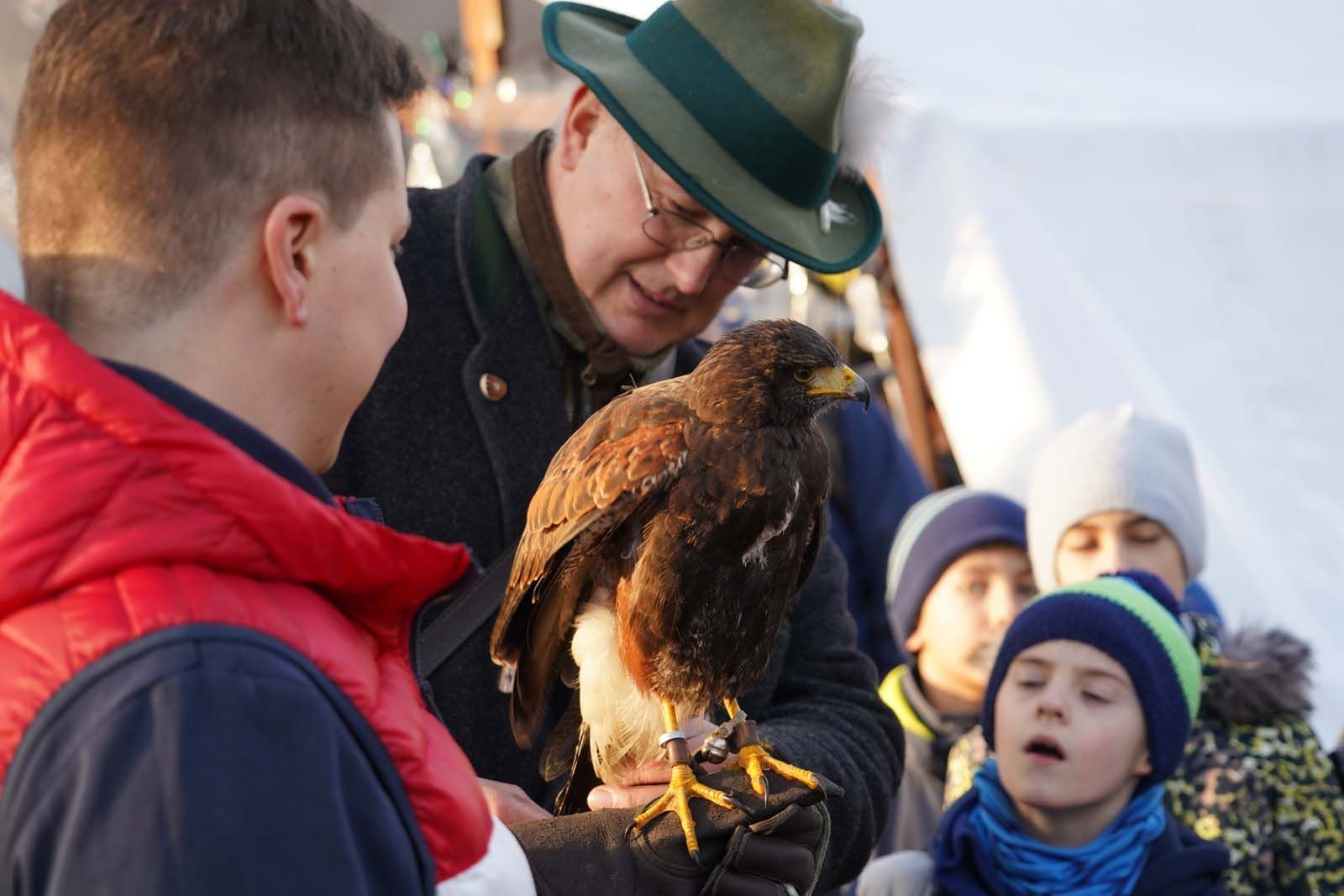 Oliver Peipe erklärt einem jungen Gast die Handhabung des schützenden Handschuhs. Das war bei Weihnachten in Westend vom 16. - 17. Dezember 2023.