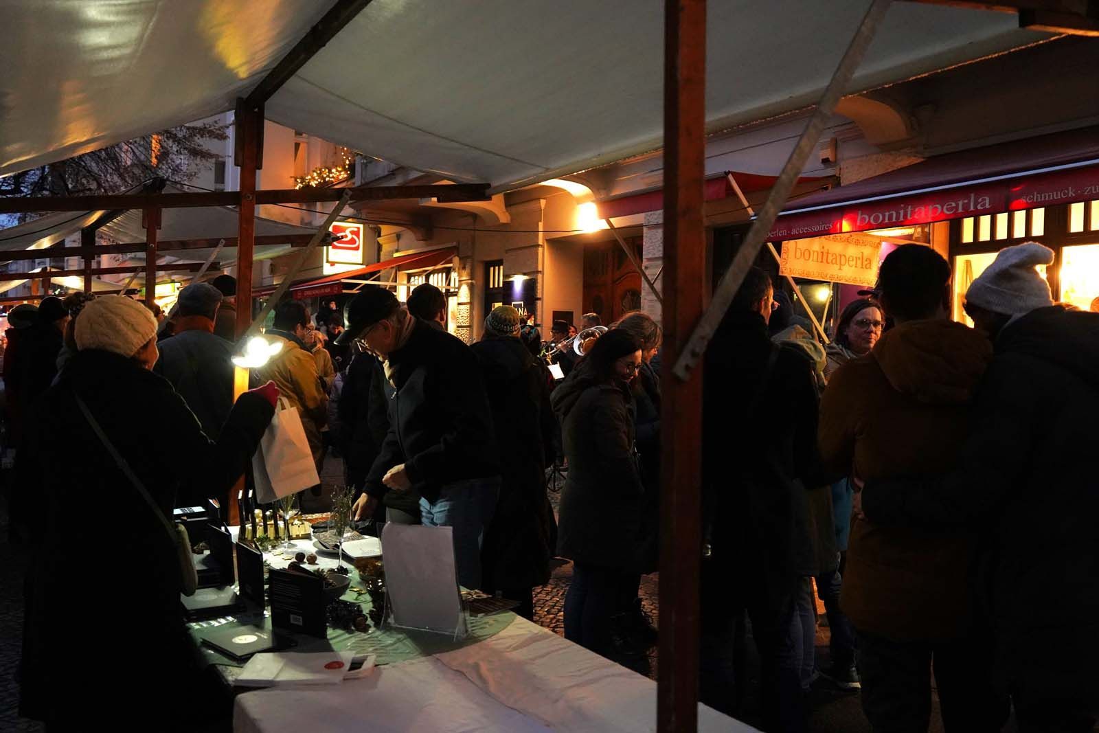 Abendliche Stimmung in der Leonhardtstraße Abendlicher Adventsmarkt in der Leonhardtstraße: Besucher:innen unter Zelten, Lichter, Gespräche, Winterstimmung